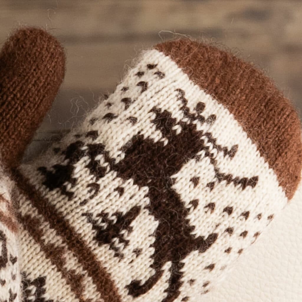 Moufles chaudes en laine marron foncé et écru, avec un joyeux motif de cerf.